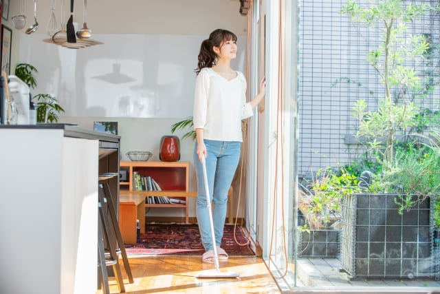 窓から外を見る女性